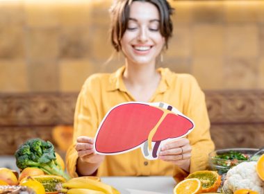 Ernährung bei Lebererkrankungen: Frau mit Lebermodell und leberfreundlichen Lebensmitteln